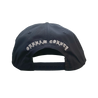 Knocked Loose's "Varsity Arch" design embroidered on the front and back of a navy Yupoong Snapback.