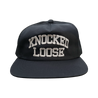 Knocked Loose's "Varsity Arch" design embroidered on the front and back of a navy Yupoong Snapback.